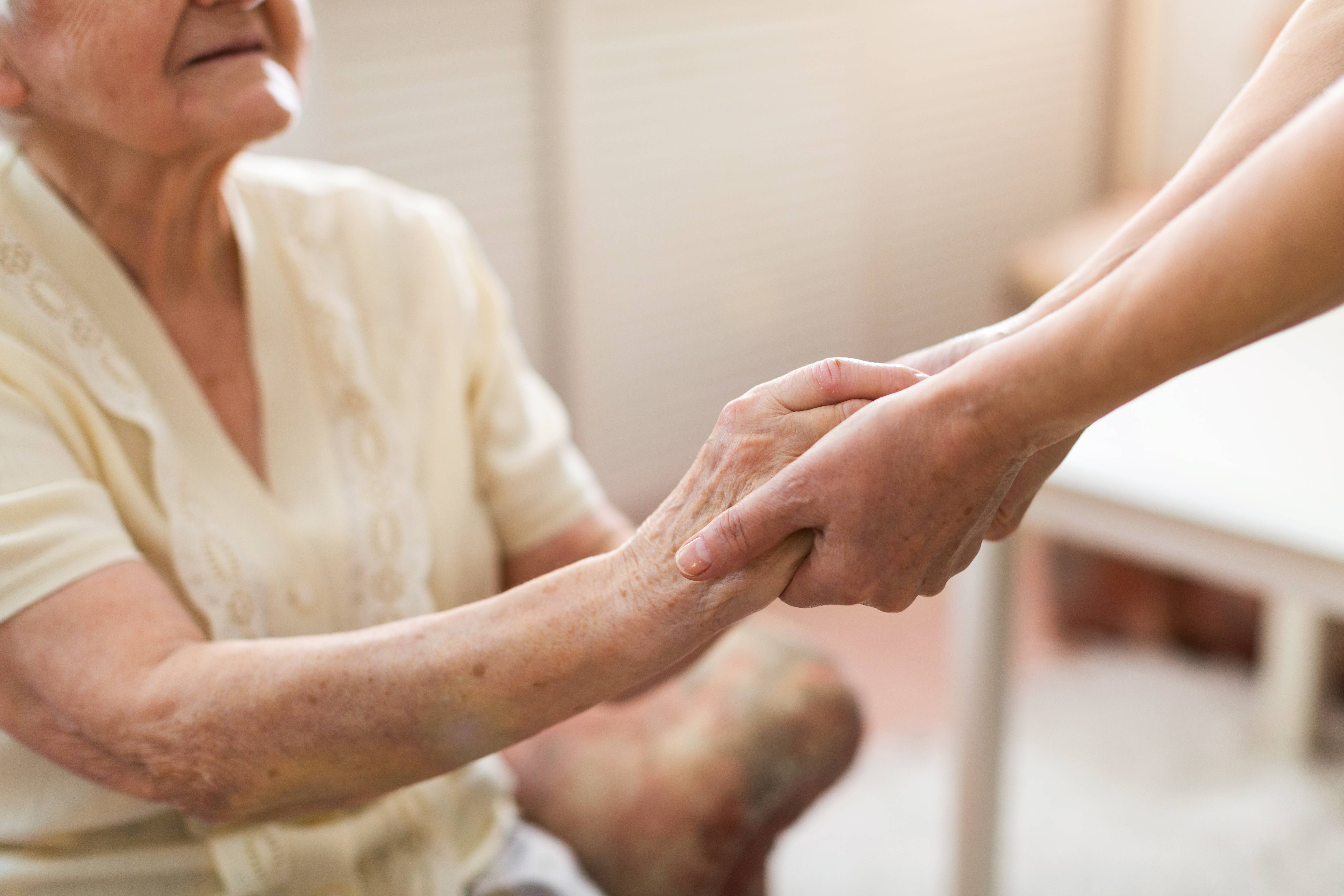 Nurse consoling her elderly patient