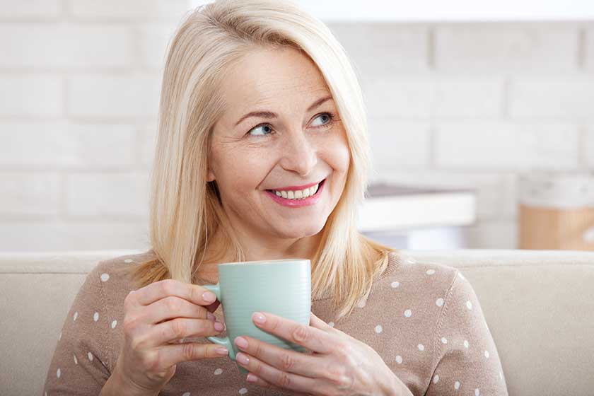 Portrait of happy blonde with mug in hands